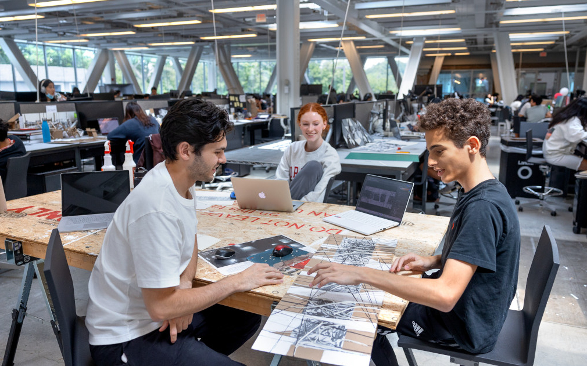 Students working in the open floor plan second floor of Milstein Hall