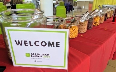 Glass jars with event food next to a reusable sign, demonstrating how to reduce waste at an event
