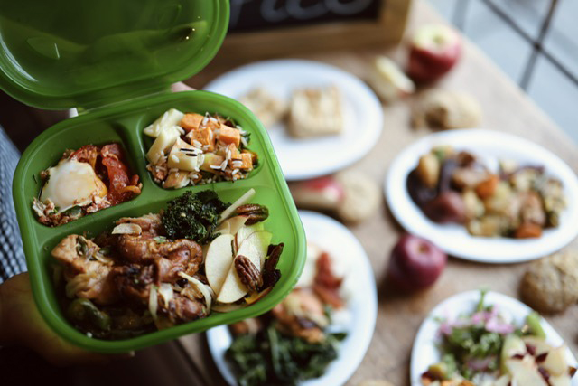 Filling a "to-go" container with food. 