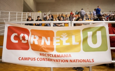 Students hold a banner for Recyclemania while at a basketball game