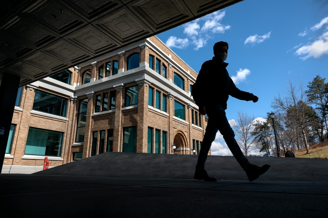 Student walking across campus with snow on buildings