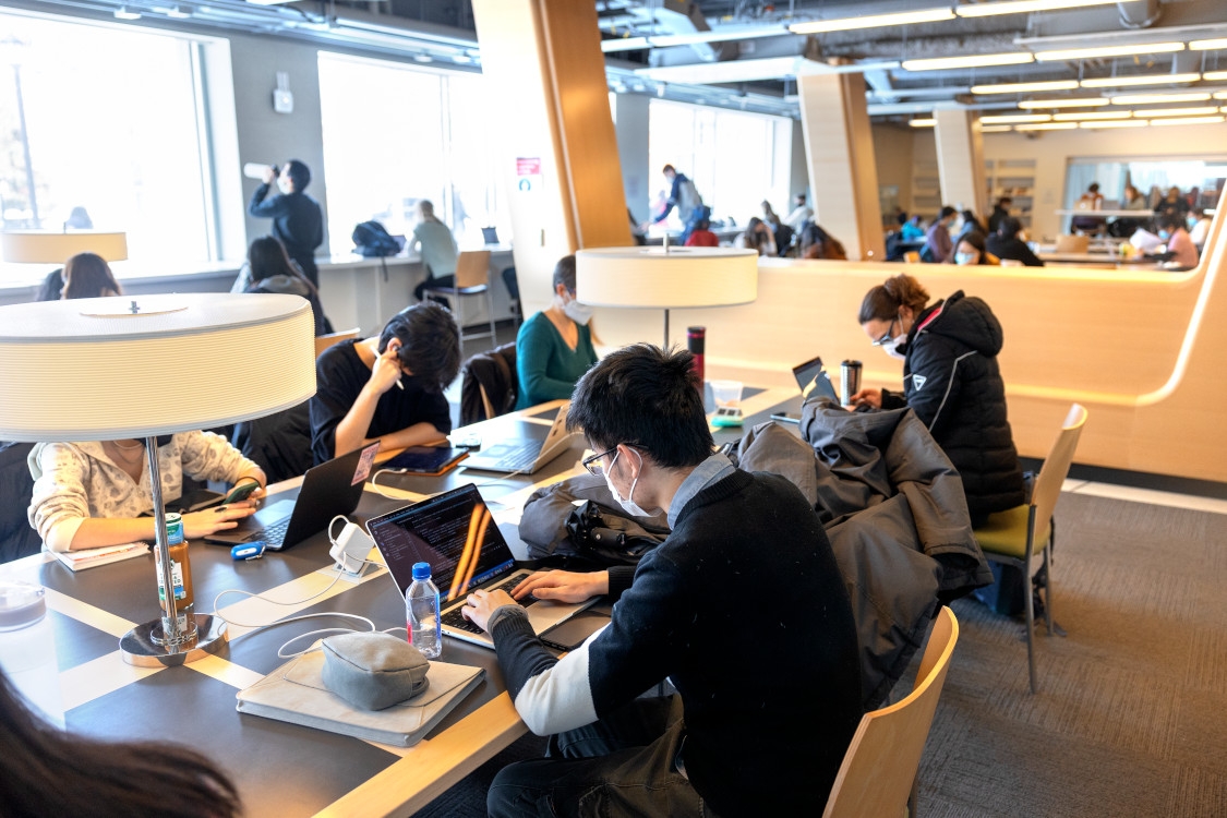 Students sitting in Statler Hall reading by a window
