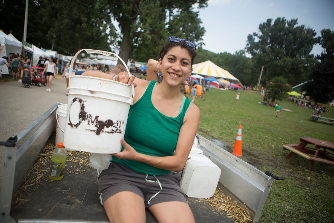 Student sitting on truck holding a compost bucket